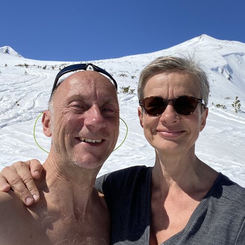 Selfie of Ralf and Andrea in the snow below a mountain peak